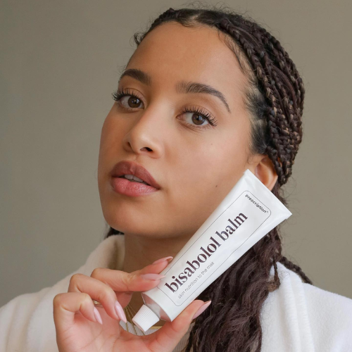 Model houdt Prescription Skincare Bisabolol Balm vast bij haar gezicht
