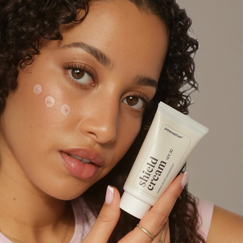 Model brengt Prescription Skincare Shield Cream SPF 30 aan op haar wang